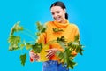 Portrait of happy woman in studio with plant, smile and happiness with house plants on blue background. Gardening Royalty Free Stock Photo