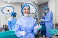 Portrait of happy woman surgeon standing in operating room, ready to work on a patient. Female medical worker in surgical uniform Royalty Free Stock Photo