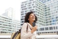 Happy woman walking in the city with mobile phone and listening to music with earphones Royalty Free Stock Photo