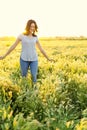 Portrait of a Happy woman walking among the wild flowers on a summer evening Royalty Free Stock Photo