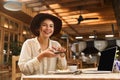 Portrait of happy woman wearing hat photographing food on cell phone