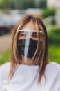 Portrait happy woman wile wearing a face shield for protection from cold and flu and viruses. Young woman with face mask