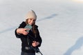 Portrait of a happy woman in winter cloth making selfie photo on smartphone while skating on the ice rink. Royalty Free Stock Photo