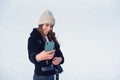 Portrait of a happy woman in winter cloth making selfie photo on smartphone while skating on the ice rink. Royalty Free Stock Photo