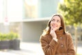 Happy woman in winter in the street thinking looking at side Royalty Free Stock Photo