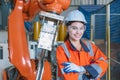 portrait happy woman worker with robot assembly machine in modern metal industry factory