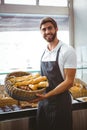 Portrait of happy worker holding basket of bread Royalty Free Stock Photo