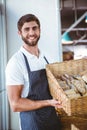 Portrait of happy worker holding basket of bread Royalty Free Stock Photo