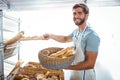 Portrait of happy worker holding basket of bread Royalty Free Stock Photo