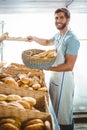 Portrait of happy worker holding basket of bread Royalty Free Stock Photo