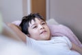 Portrait happy yong boy lying on sofa relaxing at home, Head shot cute kid looking at camera with smiling face, Positive child Royalty Free Stock Photo