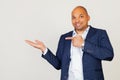 Portrait of happy young African American businessman guy, amazed and smiling at the camera, showing with hand and pointing with Royalty Free Stock Photo