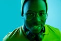 Portrait of a happy young african american man smiling on black neon background Royalty Free Stock Photo