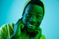 Portrait of a happy young african american man smiling on black neon background Royalty Free Stock Photo