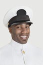 Portrait of a happy young African American US Navy officer over gray background