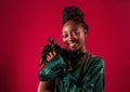 Portrait of happy young African woman smiling in green shiny party dress decorated with feathers Royalty Free Stock Photo