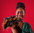 Portrait of happy young African woman smiling in green shiny party dress decorated with feathers Royalty Free Stock Photo