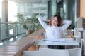 Portrait of happy young Asian business woman feeling relax and good in her office. Royalty Free Stock Photo