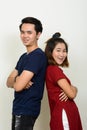 Portrait of happy young Asian couple leaning on each other with arms crossed Royalty Free Stock Photo