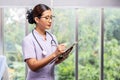 Asian female nurse in a white lab coat holds a clipboard in a hospital Royalty Free Stock Photo