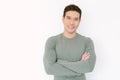 Portrait of happy young Asian handsome man in olive t-shirt standing with crossed arms and looking at camera isolated on white Royalty Free Stock Photo