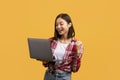 Portrait of happy young asian lady holding laptop and gesturing yes, shaking clenched fist, reading great news Royalty Free Stock Photo