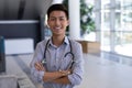 Happy Asian male doctor standing with arms crossed in hospital Royalty Free Stock Photo