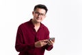 Portrait of Happy young Asian man handsome happy smile in formal red shirt using smartphone trading or chatting in studio white Royalty Free Stock Photo