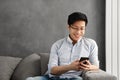 Portrait of a happy young asian man using mobile phone Royalty Free Stock Photo