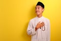 Portrait of happy Young Asian Muslim man holding prayer beads looking at a copy space aside Royalty Free Stock Photo