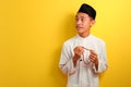 Portrait of happy Young Asian Muslim man holding prayer beads looking at a copy space aside Royalty Free Stock Photo