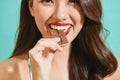 Portrait of a happy young asian woman eating chocolate bar isolated over white background Royalty Free Stock Photo