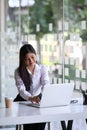 Happy young asian woman office worker smiling and working on laptop computer at office. Royalty Free Stock Photo