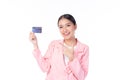 Portrait of a happy young asian woman wearing pink suit holding bank card, credit card isolated on white background. Business Royalty Free Stock Photo