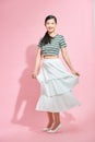 Portrait of happy young beautiful Asian lady in long skirt turning around to face camera, with copy space for advertisement Royalty Free Stock Photo