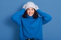 Portrait of happy young beautiful brunette girl smiling female, looking at camera, touching her head, posing isolated over blue Royalty Free Stock Photo