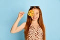 Portrait of happy young beautiful redhaired girl with long glossy hair holding lollipop and looking at camera with smile Royalty Free Stock Photo