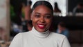 Portrait of happy young beautiful 20s gen-z black business woman with red lips smiling at camera at light trendy office. Royalty Free Stock Photo