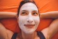 Portrait of happy young beautiful smiling sporty woman with white facial clay mask relaxing on the bed Royalty Free Stock Photo