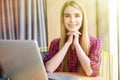 Portrait of happy young beauty woman using laptop at office table or cafe. Sun shine from windows. Royalty Free Stock Photo