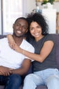 Portrait of happy young black couple posing hugging at couch Royalty Free Stock Photo