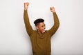 Happy young black man with arms raised in joy against gray background Royalty Free Stock Photo