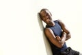 Happy young black man leaning against wall outside with arms crossed Royalty Free Stock Photo