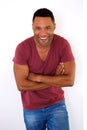 Happy young black man smiling with arms crossed against white background Royalty Free Stock Photo