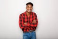 Happy young black man smiling with arms crossed by gray background Royalty Free Stock Photo