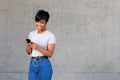 Happy young black woman looking at mobile phone and listening to music Royalty Free Stock Photo