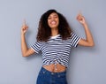 Happy young black woman smiling and pointing up Royalty Free Stock Photo