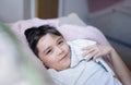 Portrait happy young boy lying on sofa playing with soft toy relaxing at home, Head shot cute kid looking at camera with smiling Royalty Free Stock Photo