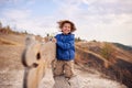 Portrait of happy young boy sitting on a wooden bench outdoors Royalty Free Stock Photo