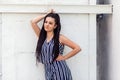 Portrait of happy young brunette woman with black afro american dreadlocks hairstyle in striped dress standing, posing and looking Royalty Free Stock Photo